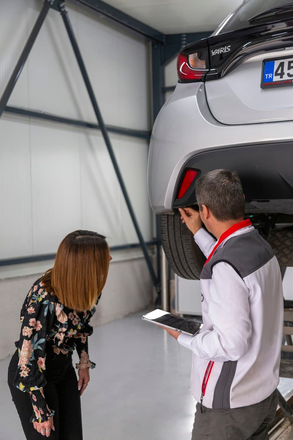 Reviewers inspecting a vehicle on a lift